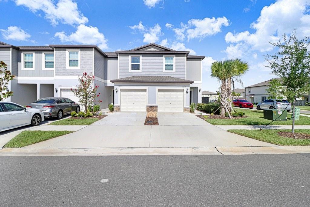 A two-story gray townhouse with a two-car garage and a concrete driveway — 10263 TRUMPET HONETSUCKLE WAY, SAN ANTONIO, FL