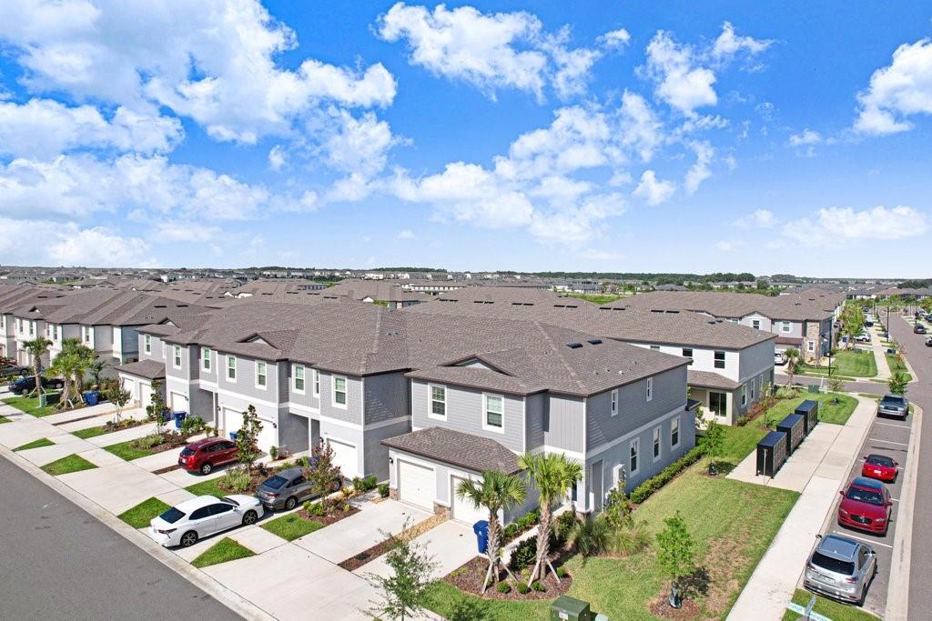An aerial view of a multi-unit townhouse complex with gray siding and asphalt shingle roofs — 10263 TRUMPET HONETSUCKLE WAY, SAN ANTONIO, FL