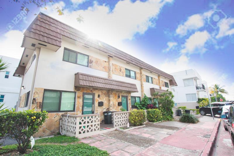 A two-story apartment building with stone veneer accents, brown mansard roofs, and decorative concrete railings — 300 80th Street, Miami Beach FL 33141, MIAMI BEACH, FL
