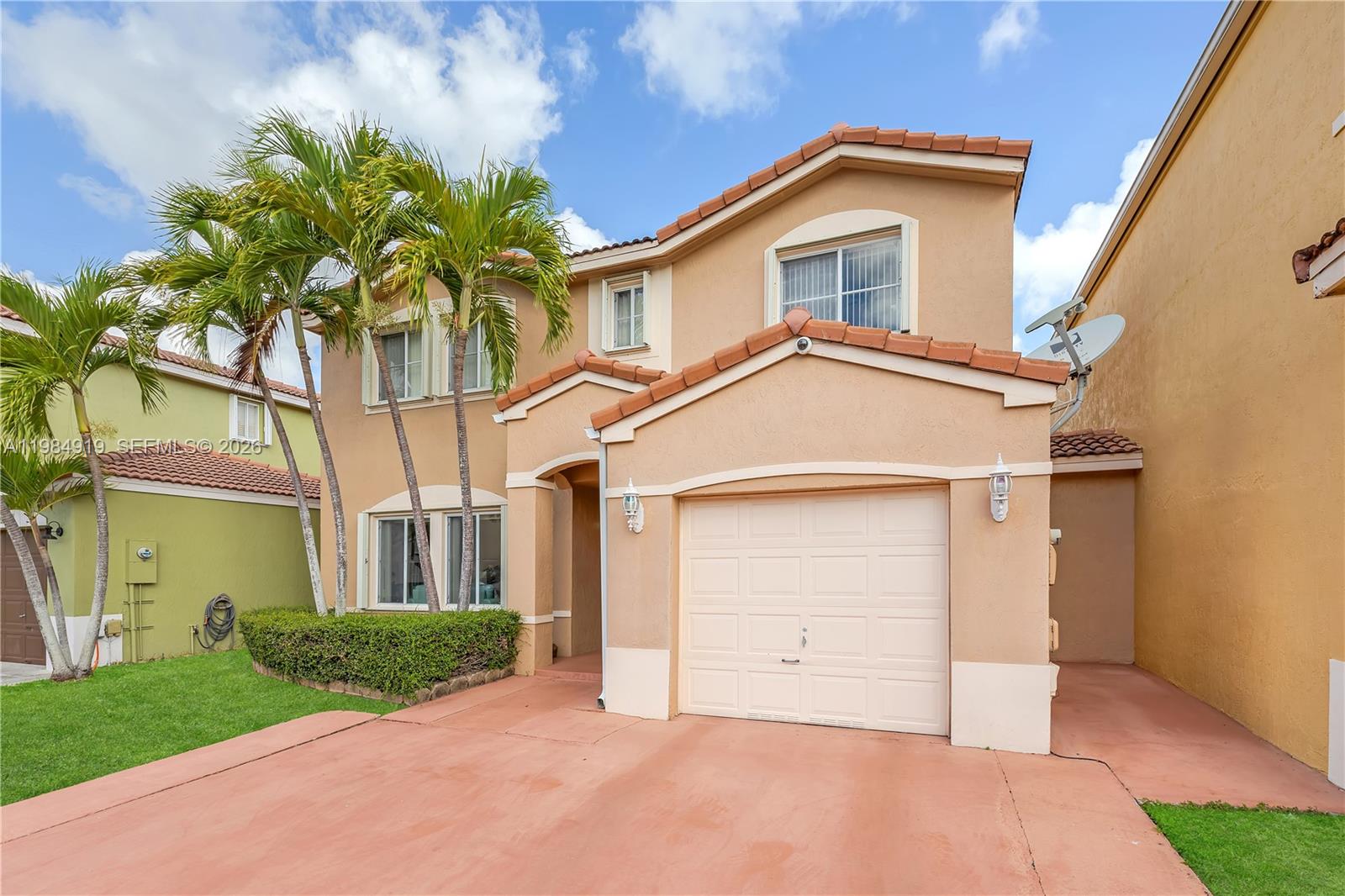 A two-story tan stucco house features a single-car garage, tile roof, and palm trees — 16323 SW 97th St, Miami FL 33196, MIAMI, FL