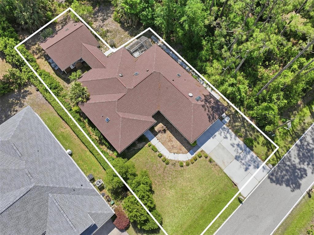 An aerial view shows a single-story house with a brown roof and a concrete driveway — 26 WOODBURY DRIVE, PALM COAST, FL