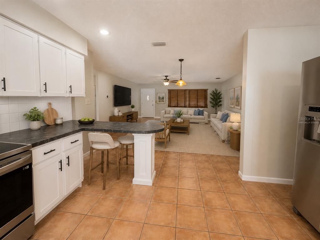 A backyard features a circular brick paver patio with a fire pit and wooden chairs — 11298 73RD AVENUE N, SEMINOLE, FL
