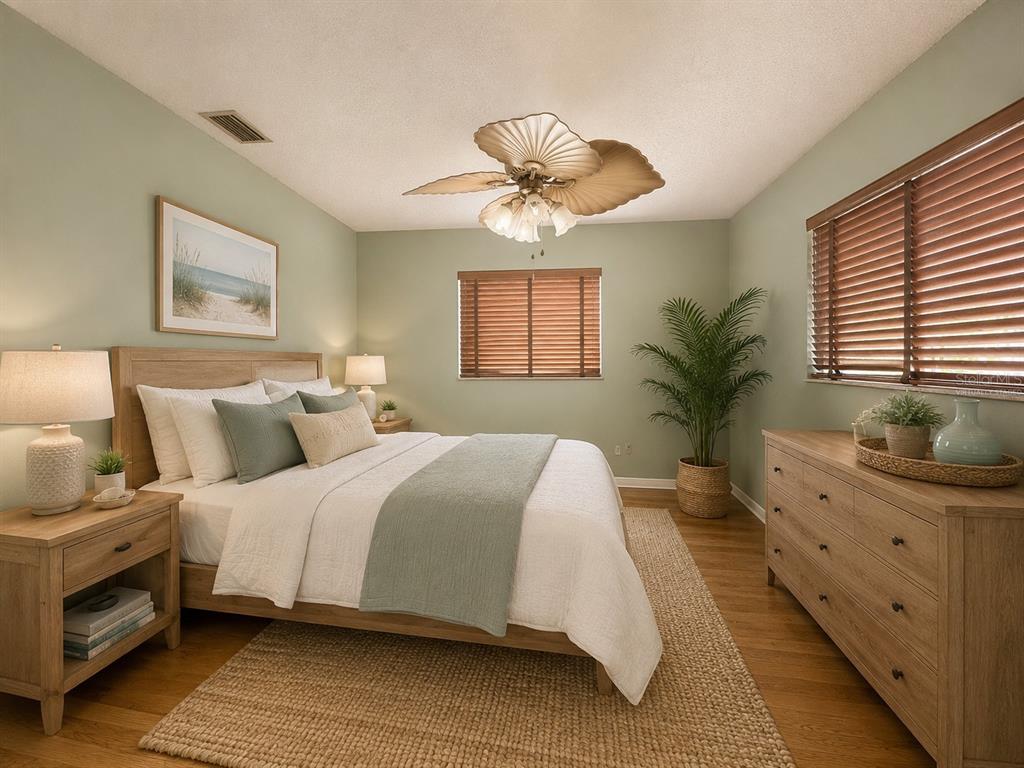 A living room features tile flooring, a beige area rug, a sofa, and a television — 11298 73RD AVENUE N, SEMINOLE, FL
