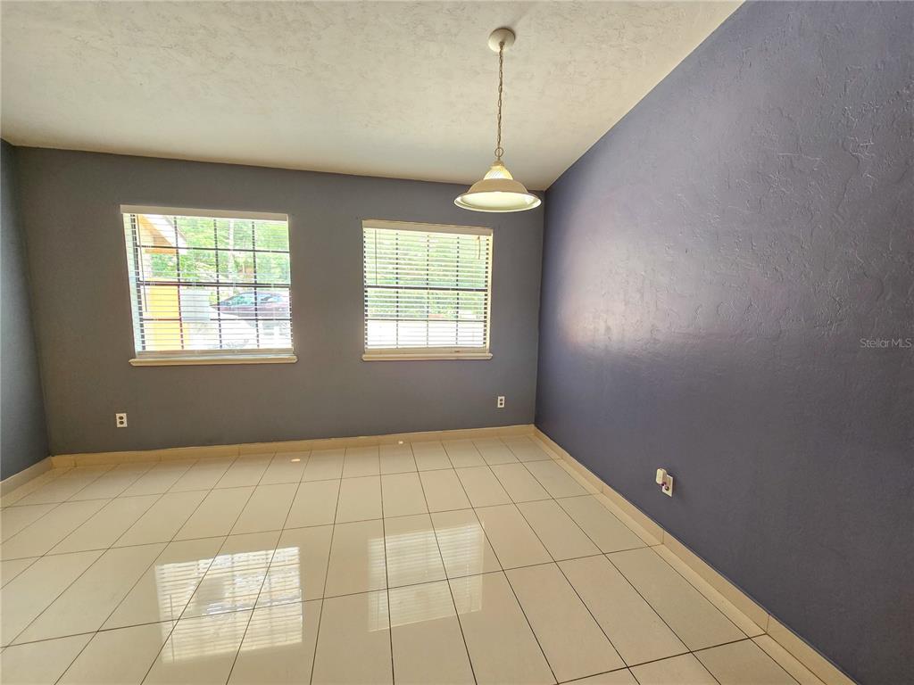 A dining room with light tile flooring, two windows, and a pendant light fixture — 7030 SW 46TH AVENUE, GAINESVILLE, FL