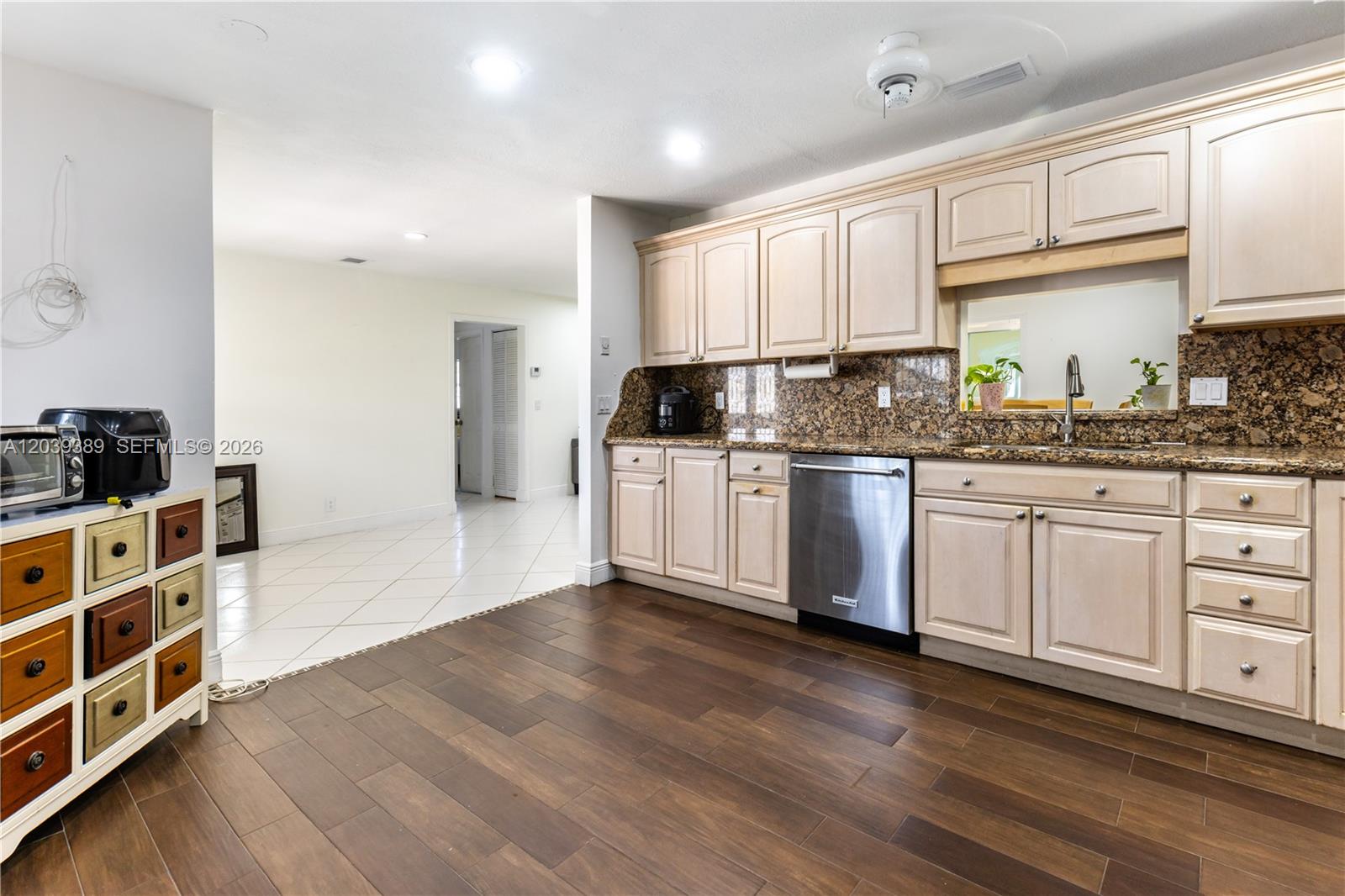 A kitchen features light wood cabinets, granite countertops, stainless steel appliances, and dark wood flooring — 19323 Carolina Cir, Boca Raton FL 33434, BOCA RATON, FL