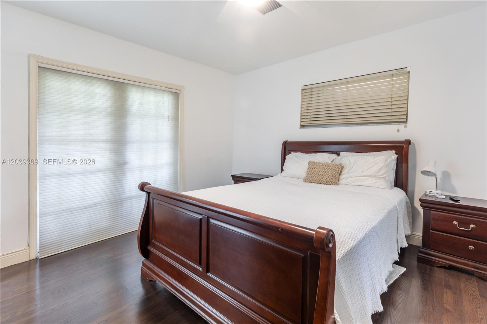 A bedroom features a dark wood sleigh bed, two matching nightstands, and dark hardwood floors — 19323 Carolina Cir, Boca Raton FL 33434, BOCA RATON, FL