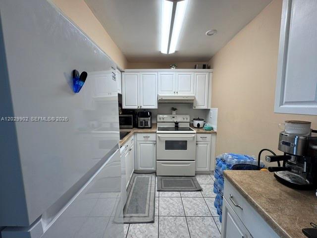 A kitchen features white cabinetry, a white stove, a refrigerator, and tiled flooring — 11780 SW 18th St # 2, Miami FL 33175, MIAMI, FL