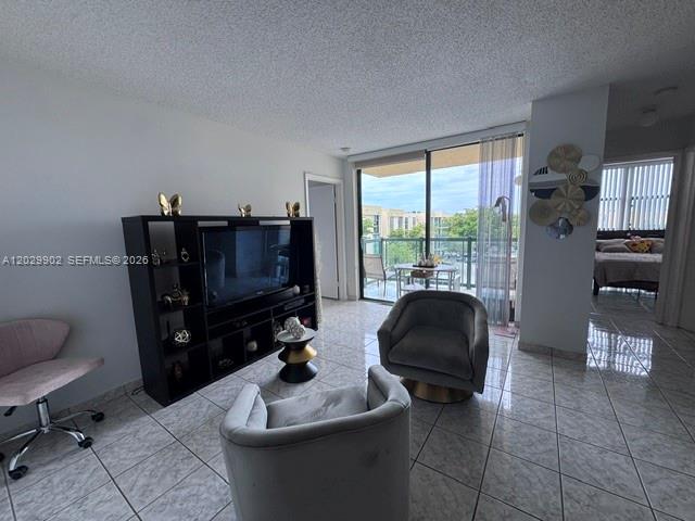 A living room features tile flooring, a black media console, and two gray armchairs — 11780 SW 18th St # 2, Miami FL 33175, MIAMI, FL