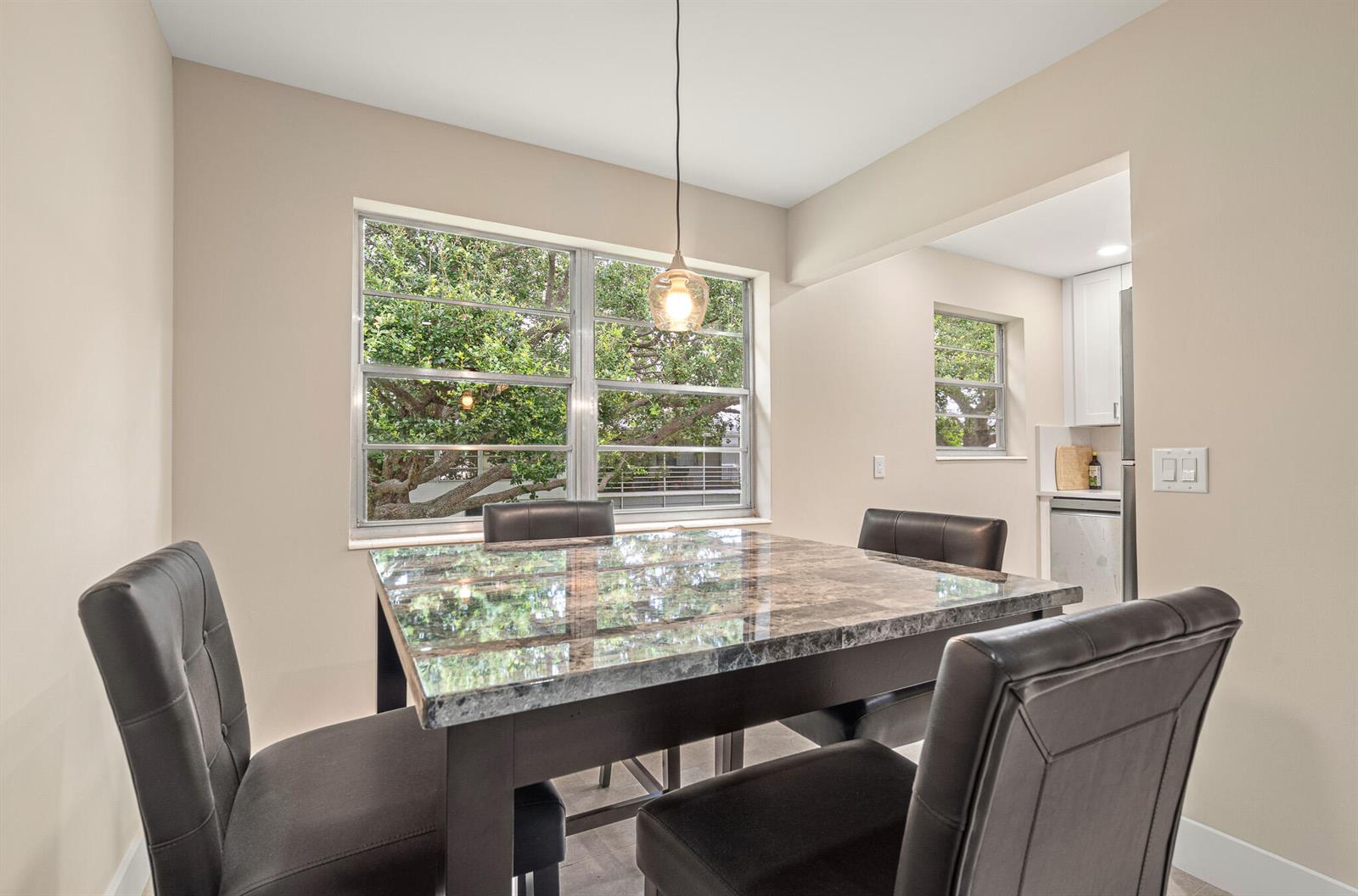 A dining area features a marble-topped table, four dark chairs, and a large window — 168 Farnham, Deerfield Beach FL 33442, DEERFIELD BEACH, FL