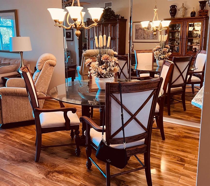 A dining area features a glass table, wooden chairs, and a large wall mirror — 8750 OLDE HICKORY AVENUE UNIT 9105, SARASOTA, FL
