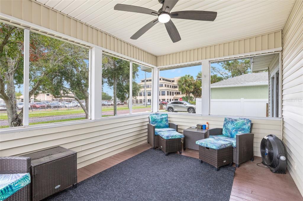 A screened-in porch with a ceiling fan, wicker furniture, and a view of a parking lot — 605 3RD AVENUE SW, LARGO, FL