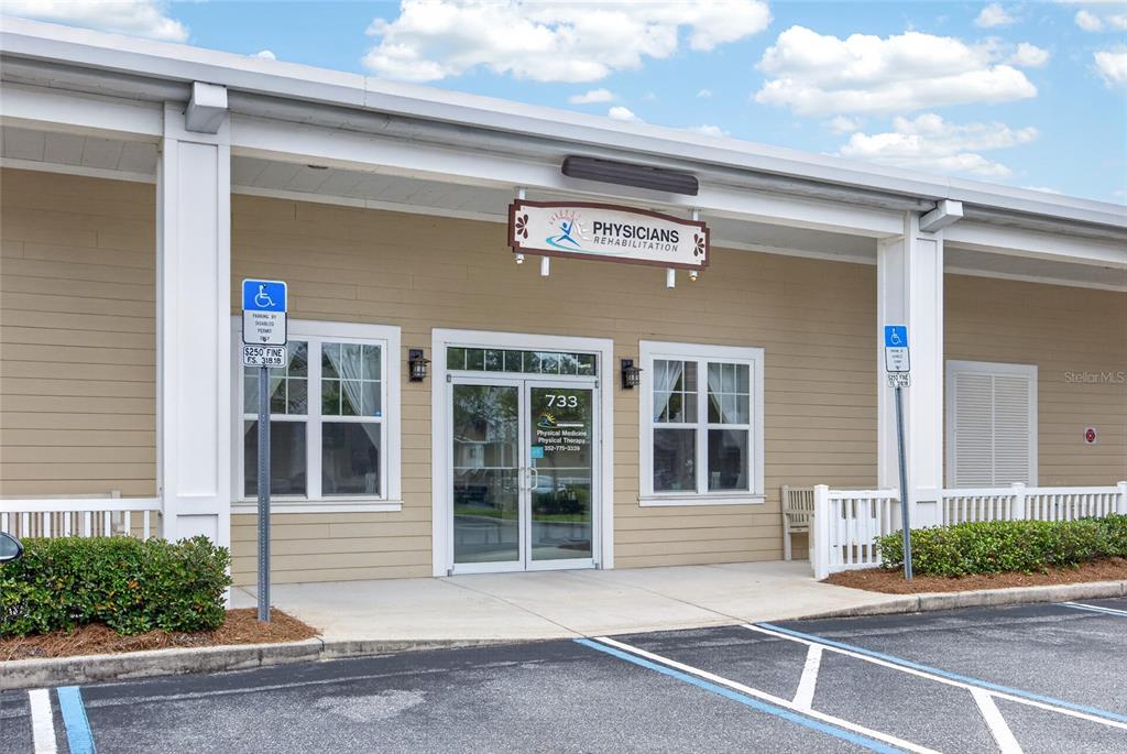 The exterior of a commercial building with a Physicians Rehabilitation sign above the glass entrance — 733 COUNTY ROAD 466, LADY LAKE, FL