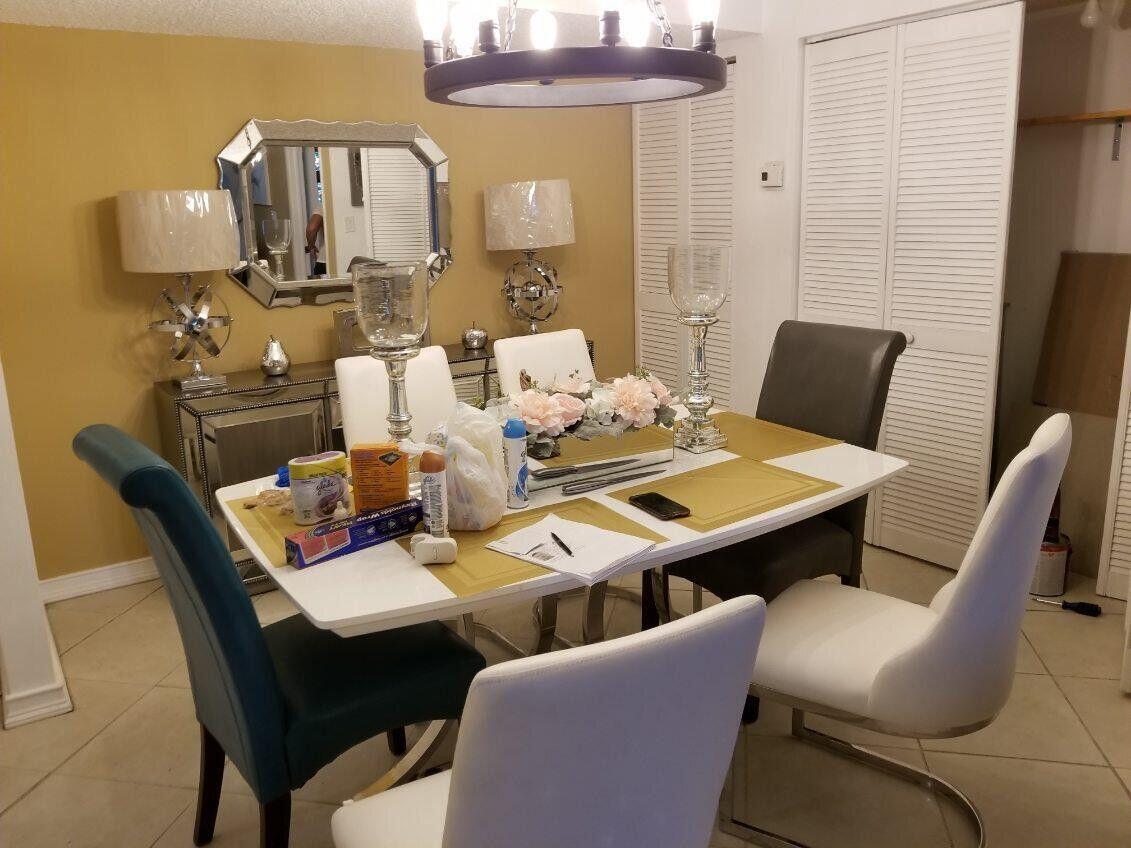 A dining room features a white table, mixed chairs, a chandelier, and a mirrored sideboard — 733 SE 1st Way # 105, Deerfield Beach FL 33441, DEERFIELD BEACH, FL