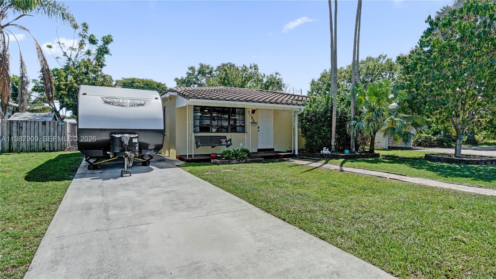 A single-story house with a tiled roof, a brick walkway, and a parked travel trailer — 1007 N 31st Rd, Hollywood FL 33021, HOLLYWOOD, FL