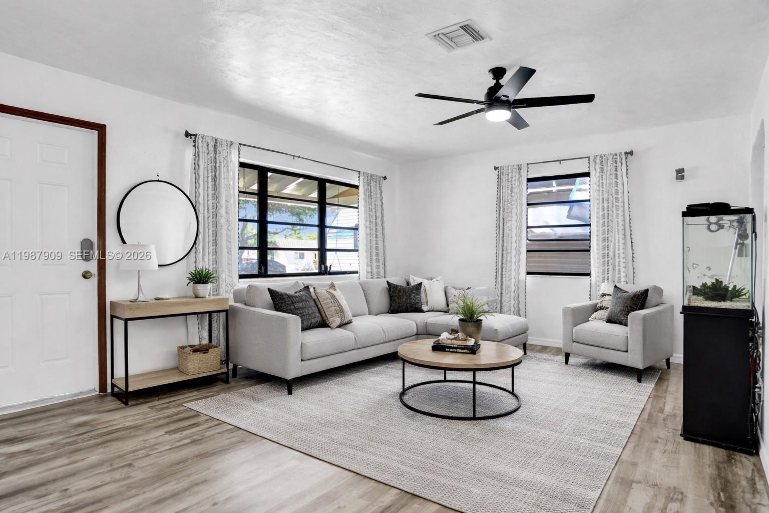 A living room features a sectional sofa, armchair, coffee table, and a fish tank — 1007 N 31st Rd, Hollywood FL 33021, HOLLYWOOD, FL