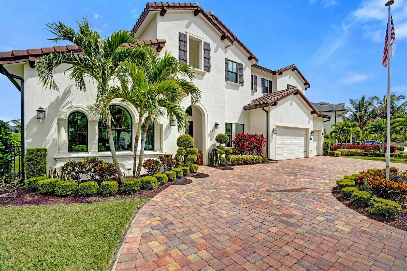 A two-story stucco house with a tiled roof, arched windows, and a brick paver driveway — 9420 Grand Prix Lane, Boynton Beach FL 33472, BOYNTON BEACH, FL