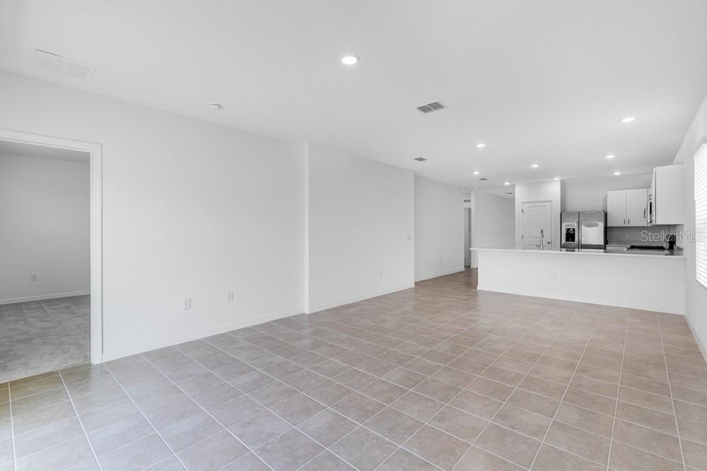 A modern kitchen features white cabinets, stainless steel appliances, and light-colored countertops — 12449 WHISK COURT, HUDSON, FL