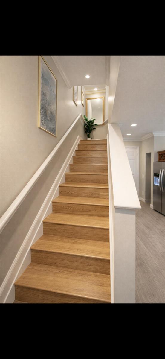 A staircase with light wood treads leads upward between white walls and a white railing — 223 Foxtail Drive # C, FL 33415, FL