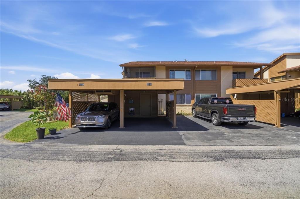 A two-story building exterior features a covered carport with two vehicles parked underneath — 4034 DAVIT DRIVE UNIT 4034, NEW PORT RICHEY, FL