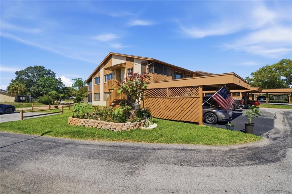 A two-story apartment building with a covered carport and a stone-bordered garden in front — 4034 DAVIT DRIVE UNIT 4034, NEW PORT RICHEY, FL