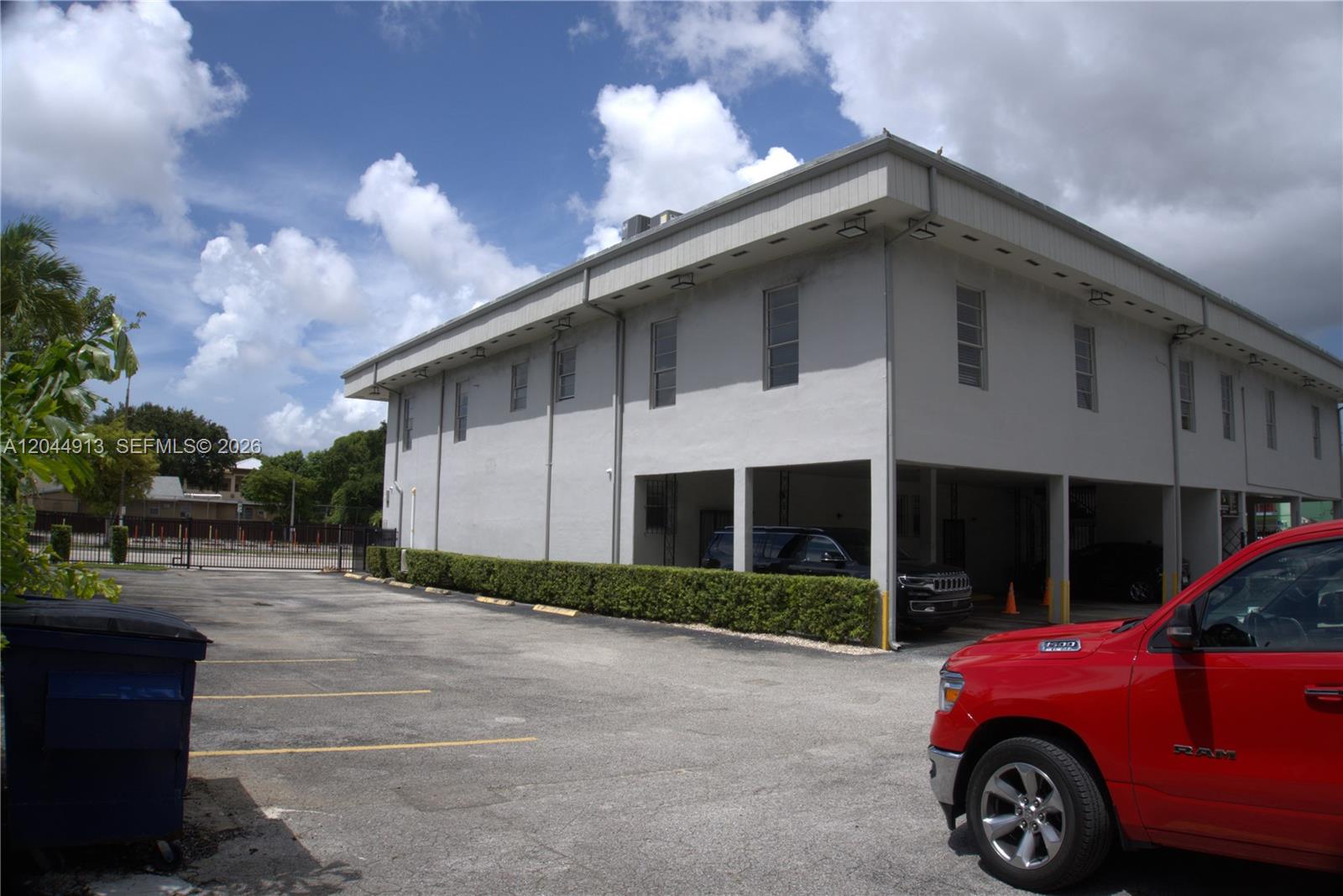 A two-story commercial building with a covered parking area and a red truck parked outside — 2433 NW 7th St, Miami FL 33125, MIAMI, FL