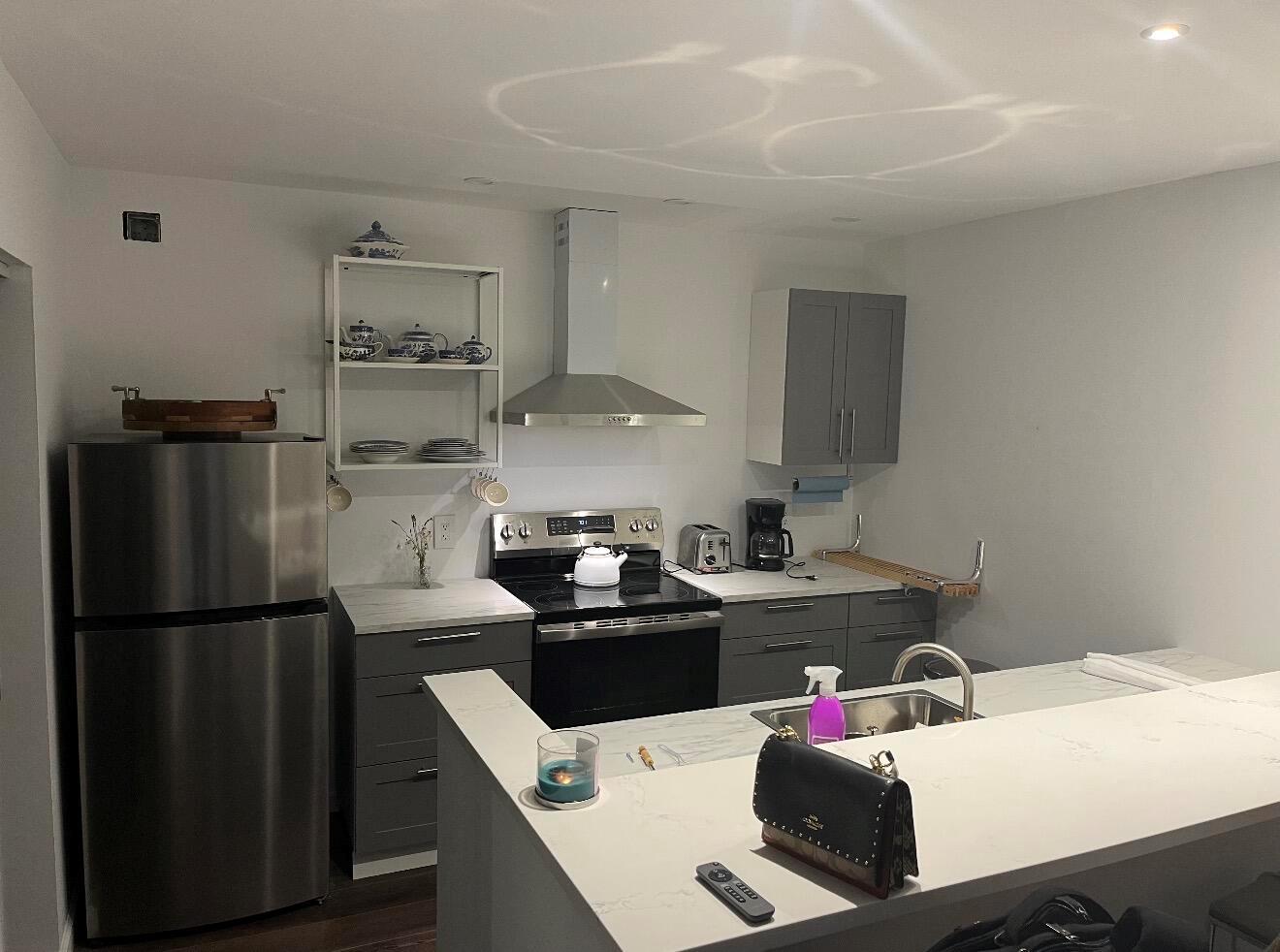 A kitchen with stainless steel appliances, grey cabinetry, white countertops, and an open breakfast bar — 2905 29th Way, West Palm Beach FL 33407, WEST PALM BEACH, FL