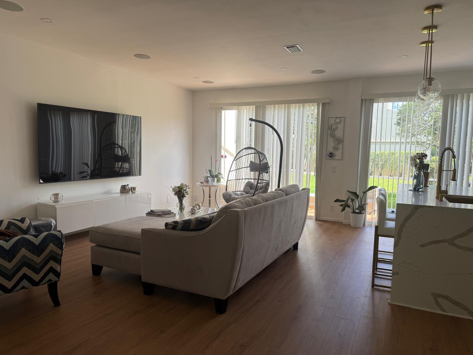 A modern living room features a large television, a sectional sofa, and a hanging chair — 6772 Via Regina, Boca Raton FL 33433, BOCA RATON, FL