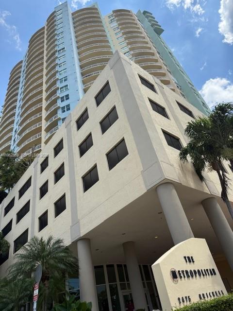 A low-angle view of a tall residential high-rise building with a prominent parking podium — 2475 Brickell Ave # 1704, Miami FL 33129, MIAMI, FL