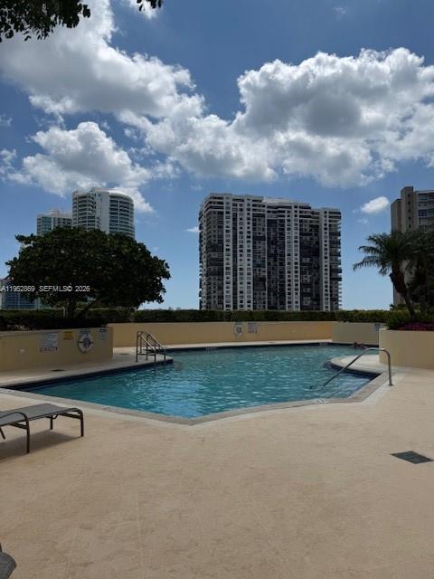 An outdoor swimming pool surrounded by a deck with high-rise buildings in the background — 2475 Brickell Ave # 1704, Miami FL 33129, MIAMI, FL
