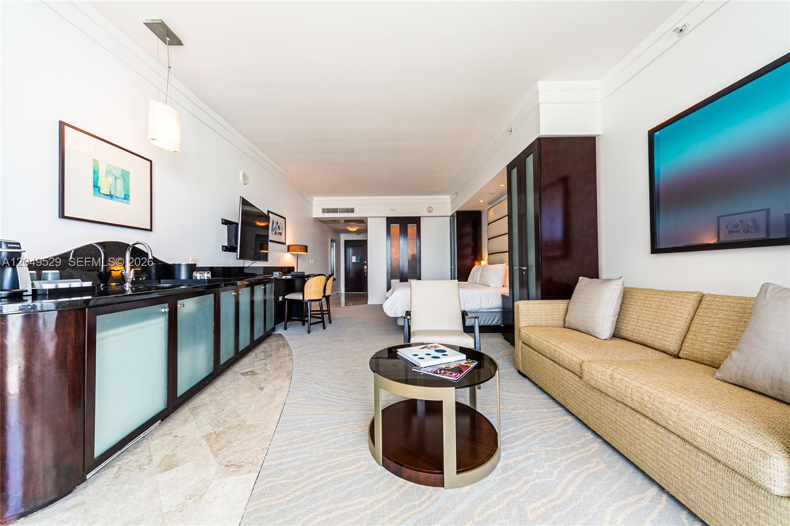 A hotel suite features a kitchenette, a seating area with a sofa, and a bed — 4391 Collins Ave # 1015, Miami Beach FL 33140, MIAMI BEACH, FL