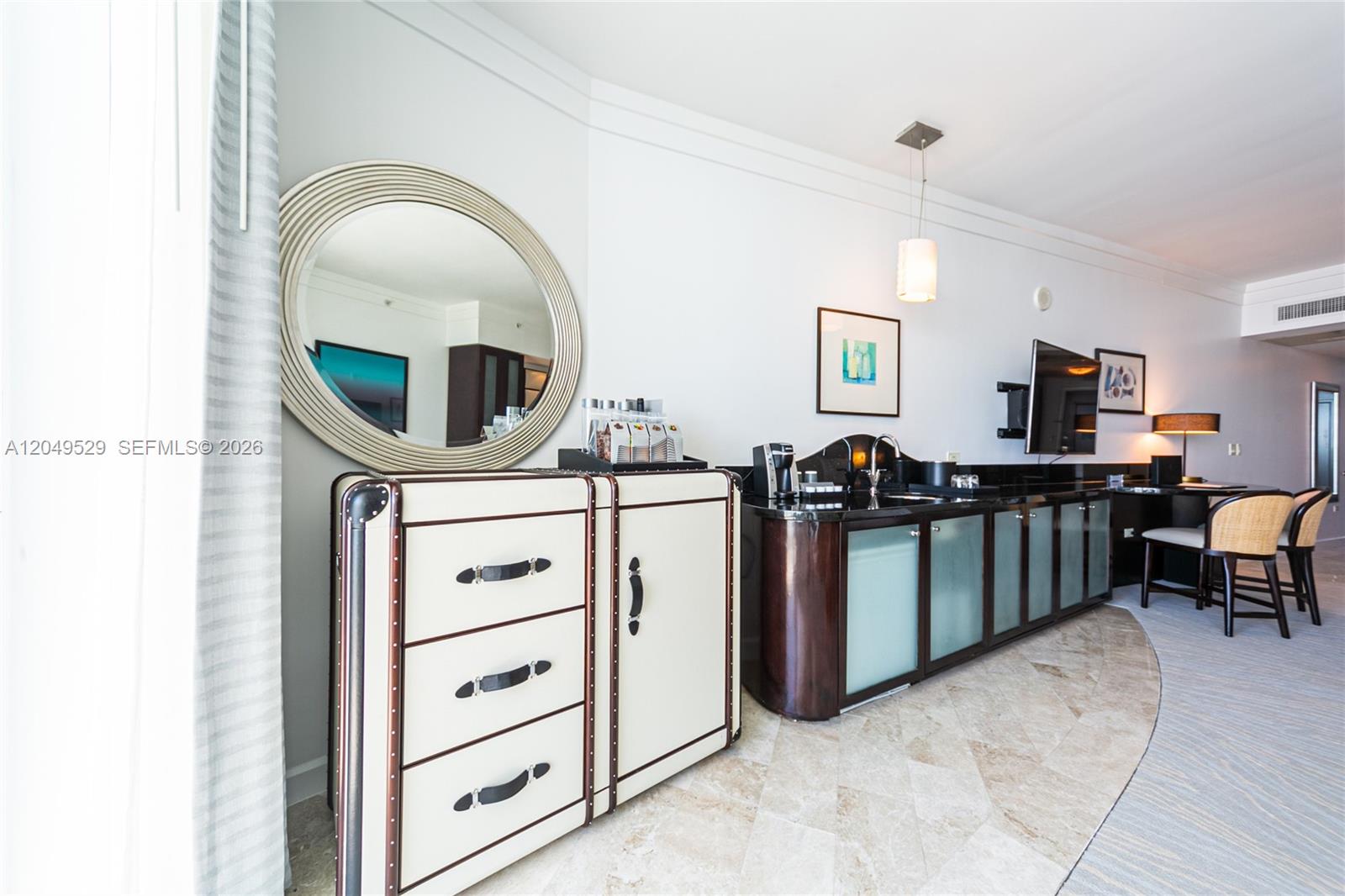 A hotel room features a trunk-style dresser, a wet bar, and a round wall mirror — 4391 Collins Ave # 1015, Miami Beach FL 33140, MIAMI BEACH, FL