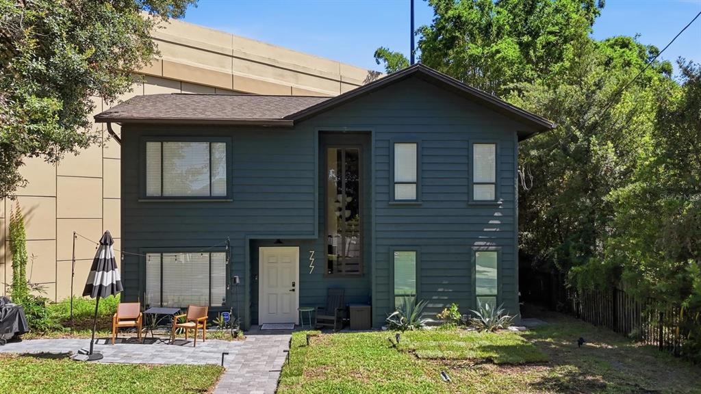 A two-story house with dark green horizontal siding and a paved patio area — 777 28TH STREET, ORLANDO, FL