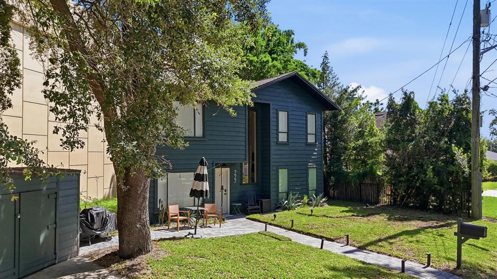 A two-story dark blue house with a paved walkway and a small front patio — 777 28TH STREET, ORLANDO, FL