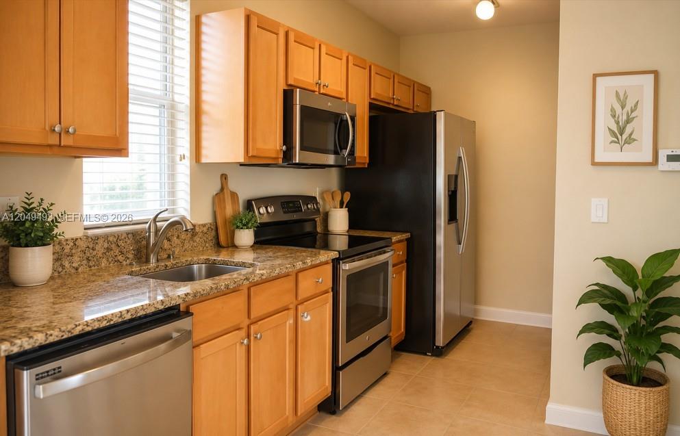 A kitchen features light wood cabinets, granite countertops, stainless steel appliances, and a tile floor — 17024 SW 95th Ter # 0, Miami FL 33196, MIAMI, FL
