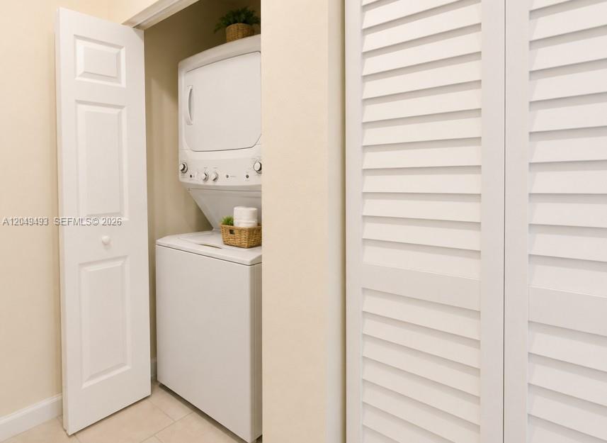 A stacked washer and dryer unit sits inside a small closet with white doors — 17024 SW 95th Ter # 0, Miami FL 33196, MIAMI, FL