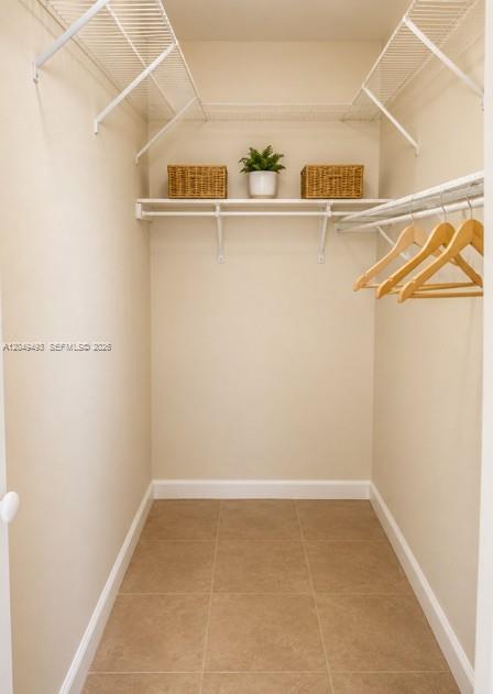 A walk-in closet features beige walls, tile flooring, wire shelving, and wooden clothes hangers — 17024 SW 95th Ter # 0, Miami FL 33196, MIAMI, FL