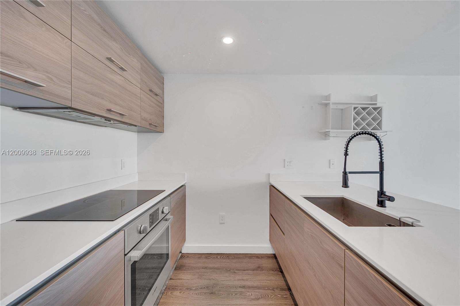 A modern kitchen features light wood cabinets, white countertops, a stainless oven, and a sink — 1300 S Miami Ave # 4711, Miami FL 33130, MIAMI, FL