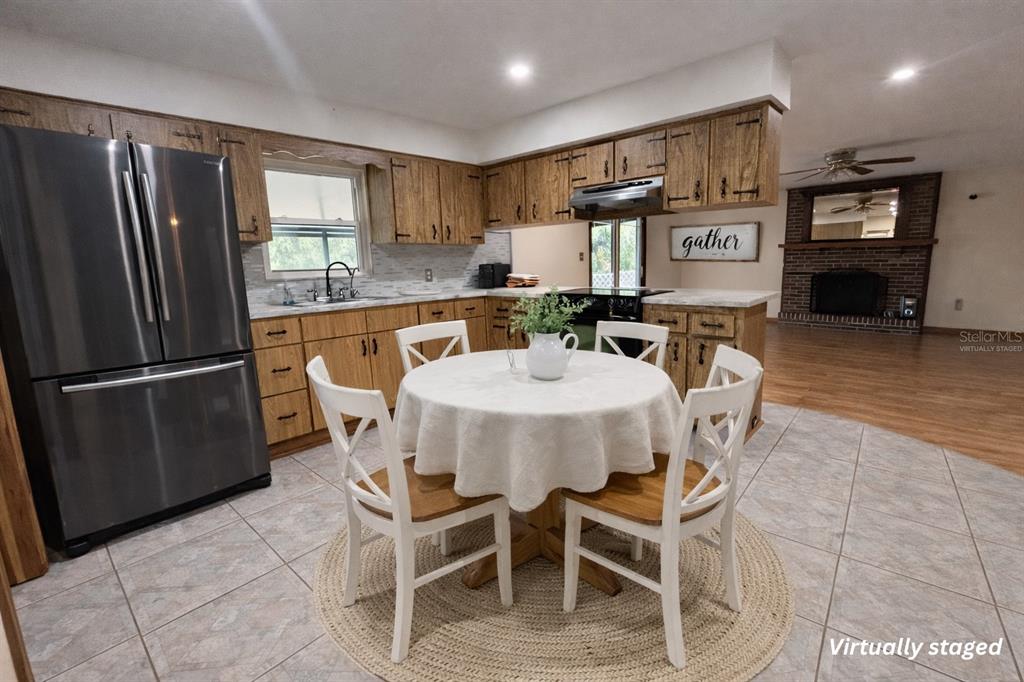 A kitchen with wood cabinets, stainless steel appliances, and a round dining table with chairs — 5028 RALSTON ROAD, LAKELAND, FL