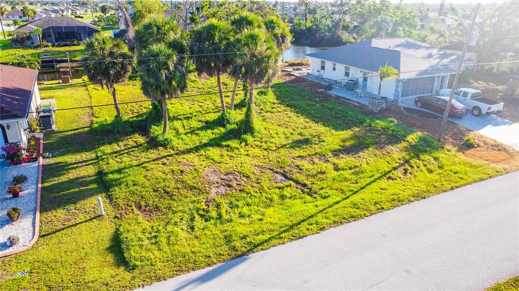 An aerial view shows a vacant grassy lot situated between two residential houses — 22 MARK TWAIN LANE, ROTONDA WEST, FL