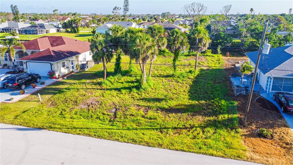An elevated view shows a vacant grassy lot situated between two residential houses — 22 MARK TWAIN LANE, ROTONDA WEST, FL
