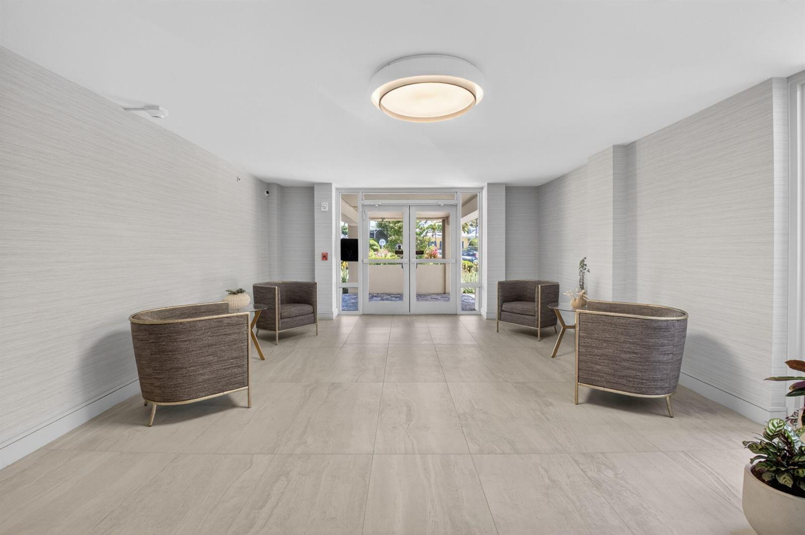 A bright lobby features light tile flooring, textured gray walls, and four modern armchairs — 2220 S Ocean Boulevard # 304, Delray Beach FL 33483, DELRAY BEACH, FL