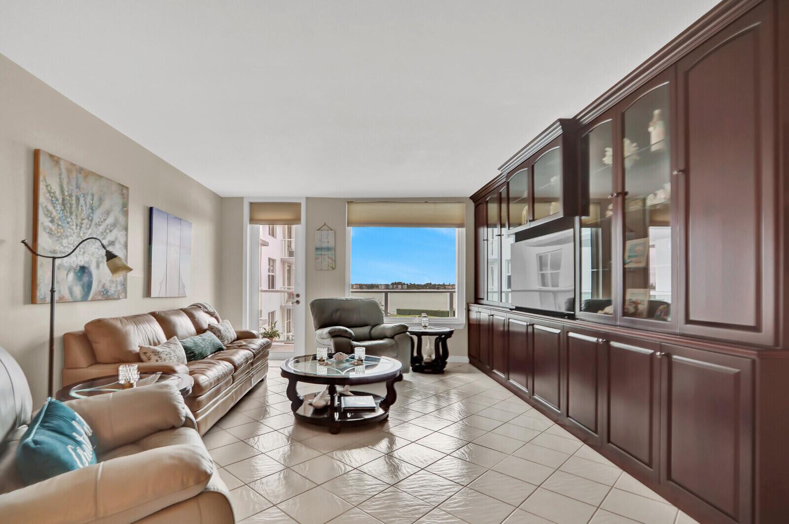 A living room features a leather sofa, a glass coffee table, and a large wall unit — 3450 S Ocean Boulevard # 327, Palm Beach FL 33480, PALM BEACH, FL