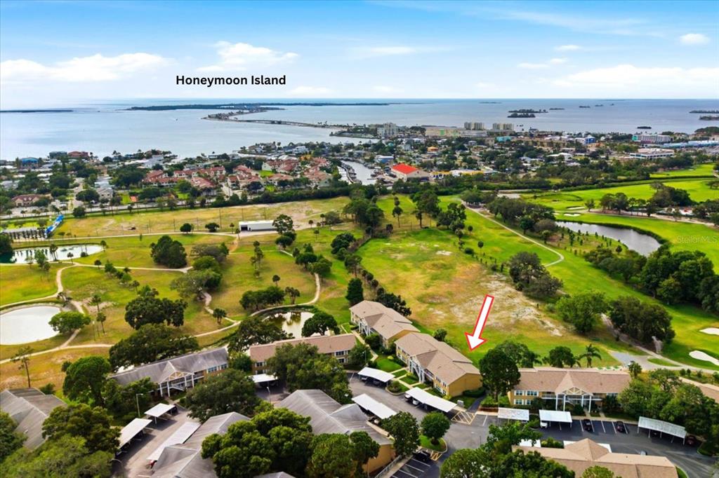 An aerial view shows a multi-story residential building situated next to a golf course — 2240 GULF VIEW BOULEVARD, DUNEDIN, FL