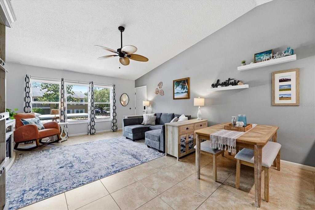 A living and dining area features tile floors, a ceiling fan, and a gray sectional sofa — 2240 GULF VIEW BOULEVARD, DUNEDIN, FL