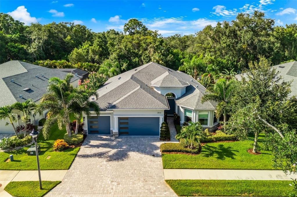 An aerial view of a single-story house with a gray roof, blue garage doors, and landscaping — 2013 BEE BRANCH COURT, PALM HARBOR, FL