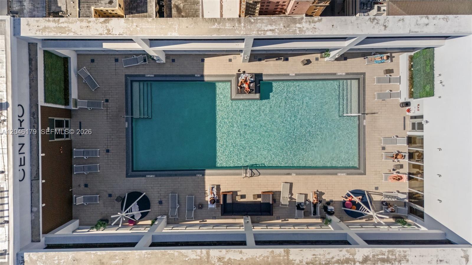 An aerial view shows a rooftop swimming pool surrounded by lounge chairs and seating areas — 151 SE 1st St, Miami FL 33131, MIAMI, FL