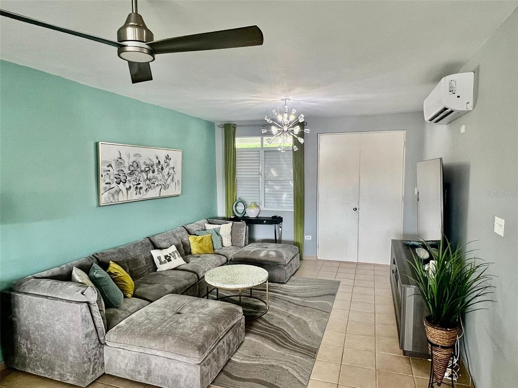 A living room features a grey sectional sofa, a teal accent wall, and tile flooring — 180 PALMAS DRIVE UNIT 38-D, HUMACAO, PR