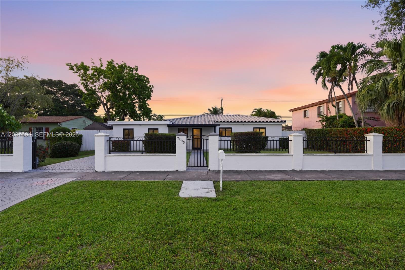 A single-story white house with a tiled roof is enclosed by a low perimeter wall — 7395 SW 39th St, Miami FL 33155, MIAMI, FL