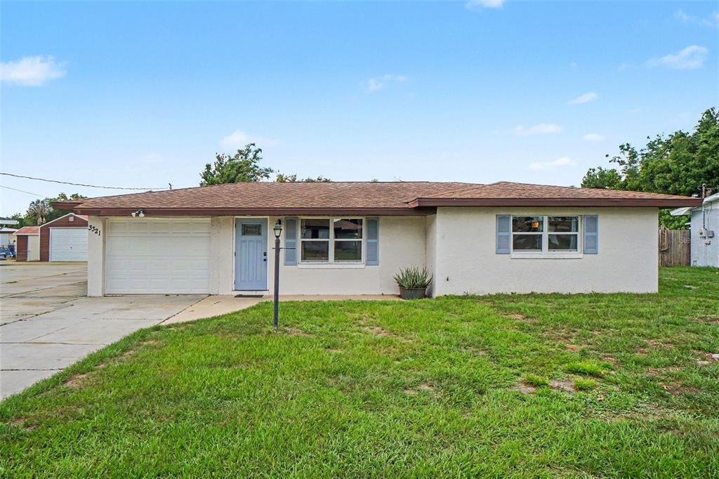 A single-story house with a white stucco exterior, a brown roof, and a garage — 3321 DAUPHINE STREET, SEBRING, FL