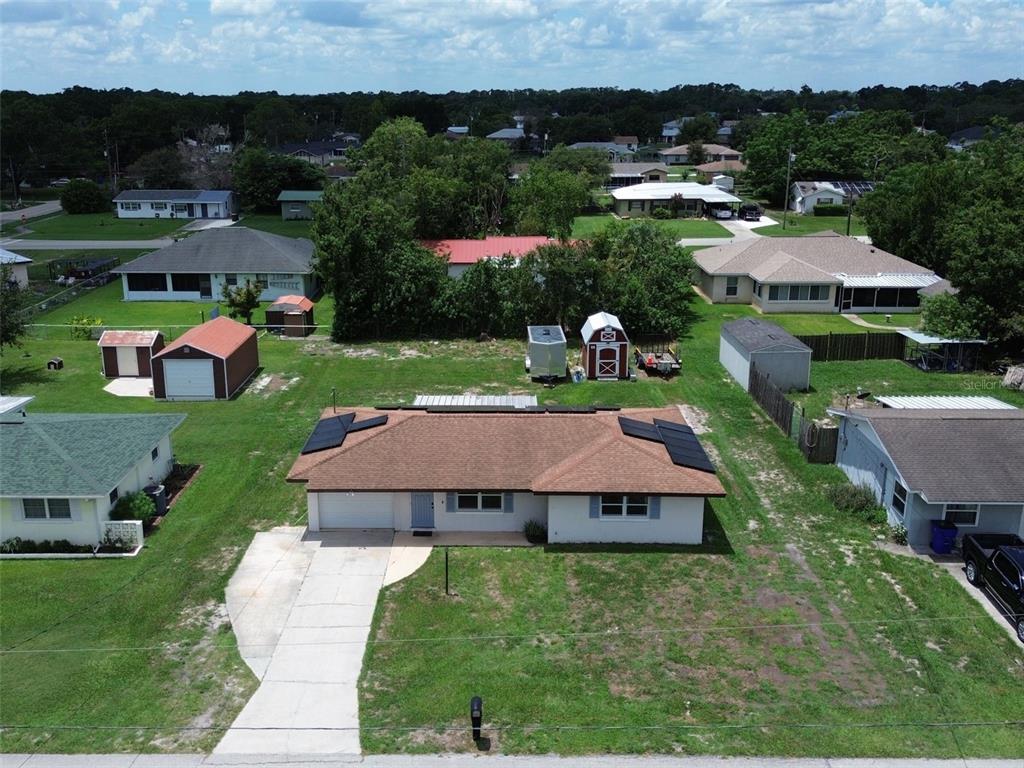 An aerial view shows a single-story house with solar panels on a large grassy lot — 3321 DAUPHINE STREET, SEBRING, FL